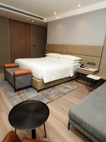 A full view of a king-sized bedroom layout, showing the integrated seating area and clean, modern design. This is a standard, informative shot for any property listing.