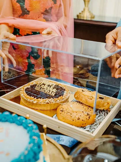 My Rakhi gift hampers are the perfect mix of sweet and savoury. This one includes a chocolate tart, bagels, and other baked goodies in a beautiful acrylic box.