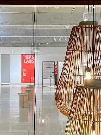 Custom-designed bamboo pendant lights created for the "Small is beautiful" exhibition. This is an example of bespoke product design that not only illuminates a space but also reinforces the thematic content of the exhibition itself.