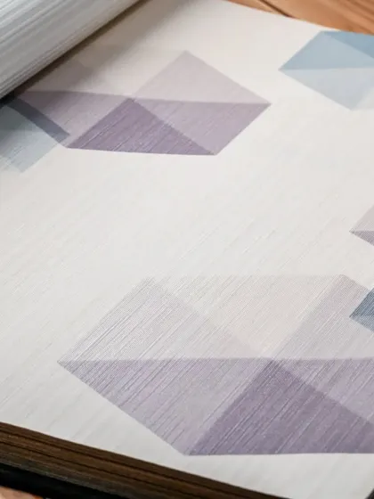 A look inside one of our wallpaper books, showcasing a modern geometric design in cool tones. Our catalogs are a great tool for visualizing how different patterns and colors will look.