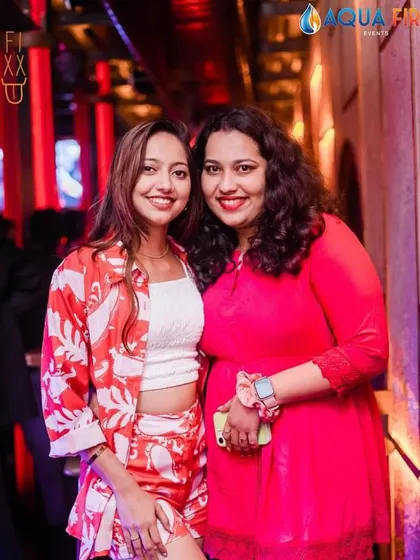 Two friends in red and white, coordinating their style for a fun night out.