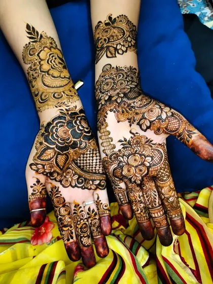 A beautiful and complex design for a wedding guest, featuring a mix of floral, peacock, and geometric elements.
