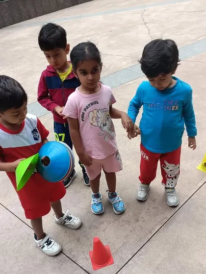 Teamwork starts here! Young children learn to cooperate and stand together during a fun football activity.