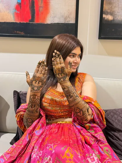 A full view of the bride's mehendi, featuring elephant processions and other royal motifs. The design covers her hands and arms completely, as is traditional for many brides.