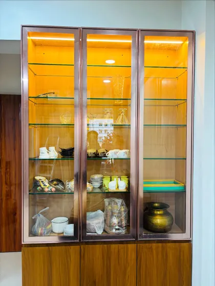 A frontal view of the elegant crockery unit, highlighting the slim rose-gold finish on the door frames.