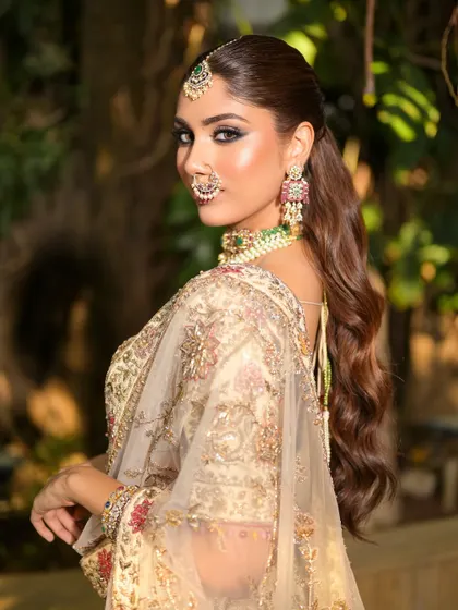 A chic ponytail adds a modern touch to this look. The side profile shows off the sculpted cheekbones and the dramatic winged eyeliner.