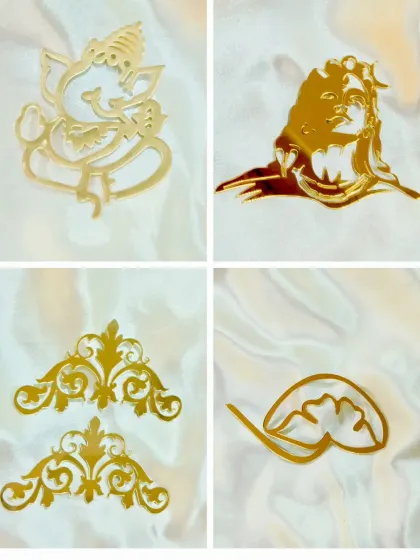 Our gold acrylic cutouts add a touch of elegance to any project. This set includes Ganesha and Shiva figures, as well as decorative corners and lotus feet for mantra frames.