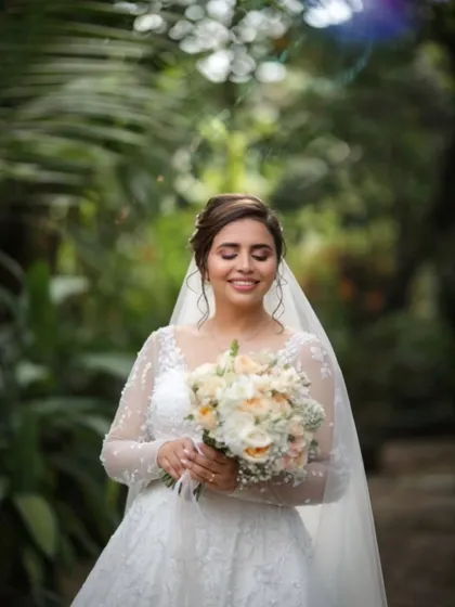 An absolute dream. This bride is glowing with happiness, her soft makeup and elegant updo perfectly complementing her long-sleeved lace gown for an outdoor shot.