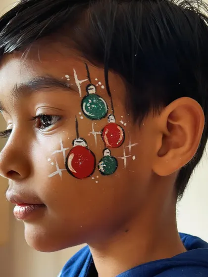 Getting into the holiday spirit with some Christmas-themed face painting. These hanging ornaments are a festive and fun design.