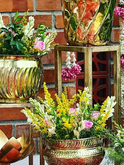 More details of the floral arrangements in brass pots, with hanging jasmine garlands adding a traditional touch to the Seemantham decor.