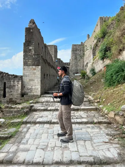 On location scouting and getting ready for a flight. I'm always exploring new places to find the perfect shot, carrying all my gear with me. This was taken at the historic Kangra Fort, a location that offers incredible cinematic potential.