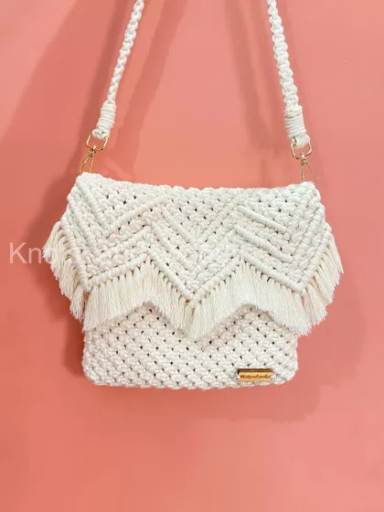 You can't go wrong with a classic! This is my white macrame sling bag, featuring a beautiful chevron pattern and a fringed flap. It's elegant, timeless, and goes with absolutely everything. Like all my bags, it's washable and made to last.
