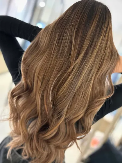 This honey blonde balayage is pure sunshine. The warm, golden tones are blended perfectly from the roots to the ends for a radiant finish.