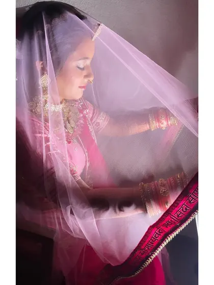 The delicate veil shot is a classic for a reason. It adds a touch of mystery and romance, beautifully framing the soft, glowing makeup and intricate details of the bride's look.