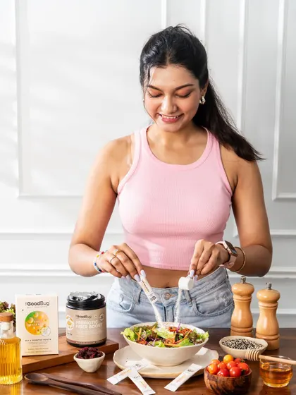 A bright and fresh shot of a model preparing a healthy salad with the client's product.