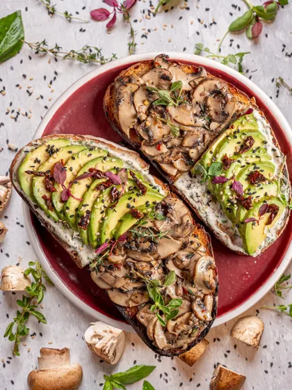A top-down view of avocado and mushroom toast. This kind of vibrant, healthy food photography is perfect for cafes looking to promote their breakfast or brunch menu.