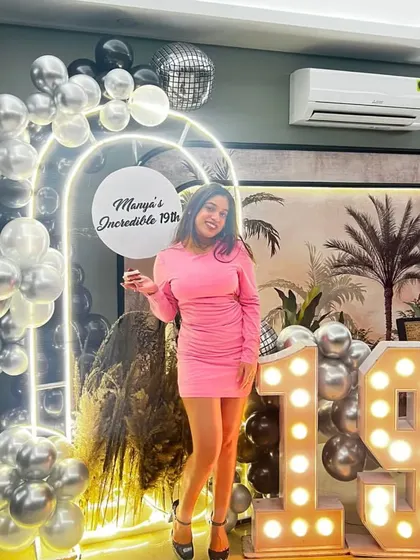 The birthday girl looking stunning next to her modern and glamorous 19th birthday decorations.