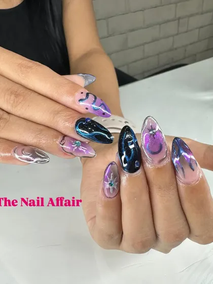 A dark and moody abstract design on stiletto nails, featuring a mix of chrome, deep blues, and purples with 3D water droplet effects.