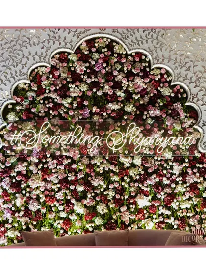 A close-up of the floral photo wall with the couple's custom hashtag. This is a perfect example of how we create personalized and highly 'Instagrammable' moments.
