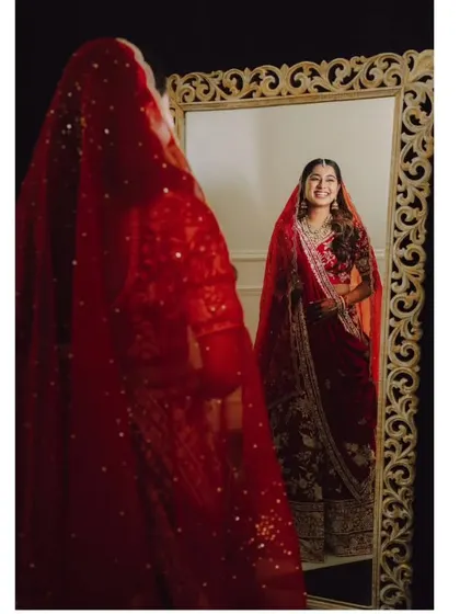 A classic bridal portrait, with the bride looking at her reflection in a mirror.