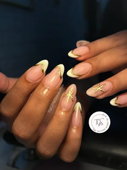 A beach-ready manicure with a sophisticated twist. This design features a white French tip with a delicate gold outline and a 3D starfish charm on the accent nail.