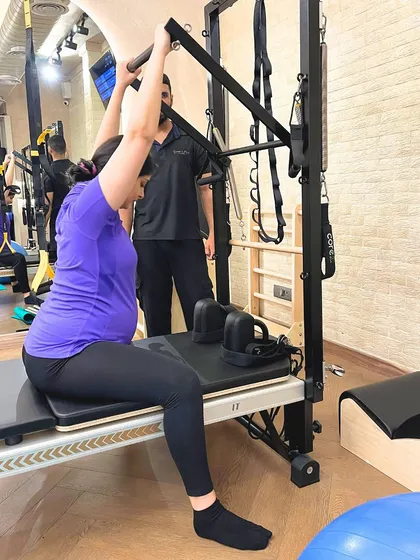 A modified seated row on the tower helps this expecting client maintain good posture and prevent back pain during her pregnancy.
