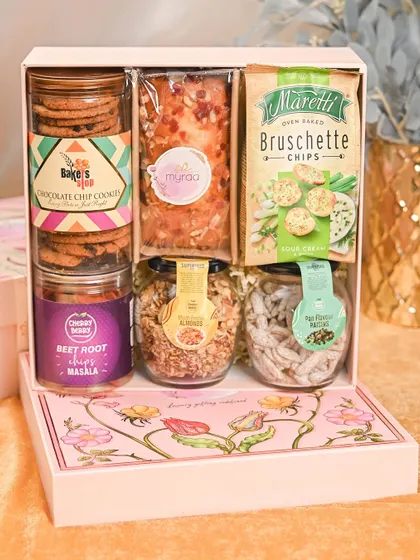 A full view of the gourmet snack hamper for Rakhi. It’s a perfect mix of sweet and savory treats, including cookies, cake, chips, and flavored nuts.