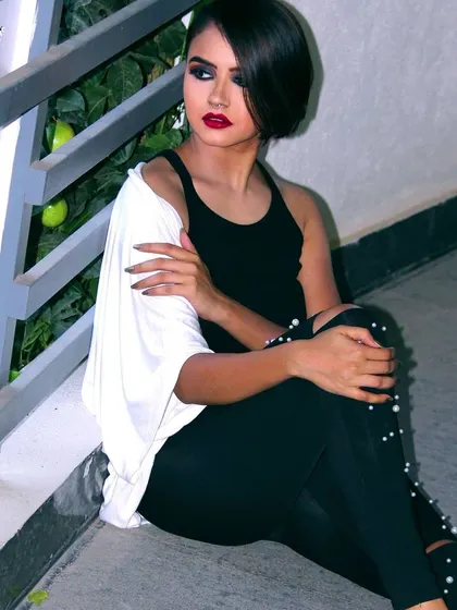 Another pose from the edgy party look series. The focus remains on the dramatic eye makeup and bold lip, demonstrating a consistent and impactful style suitable for evening wear.