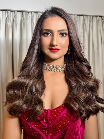 A confident and radiant portrait. The classic combination of a red lip and smokey eye is timeless and perfect for making a statement.