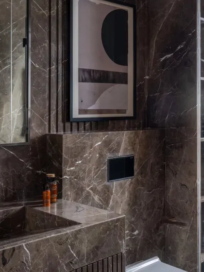 A detail of the marble-clad bathroom, where even the niche for toiletries is carefully considered and integrated into the design.