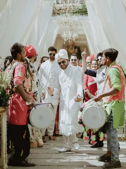 The groom makes a cool and celebratory entrance with dhol players, getting the party started for the reception.