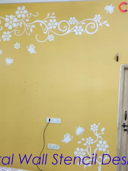 A floral wall stencil design in white applied over a warm yellow background. This cheerful and inviting pattern is perfect for brightening up a living area or entryway.