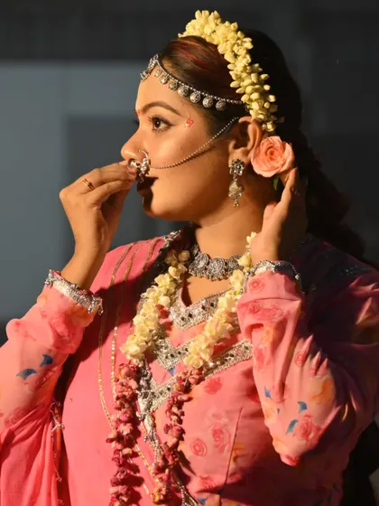A side profile showcasing the intricate details of the Radha look, including the traditional nose ring (nath) and floral headpiece (gajra).
