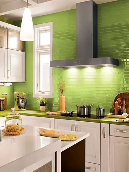 This kitchen makes a statement with a vibrant green subway tile backsplash. The white cabinets and countertops keep the look fresh and clean, while the built-in appliances provide a seamless finish.