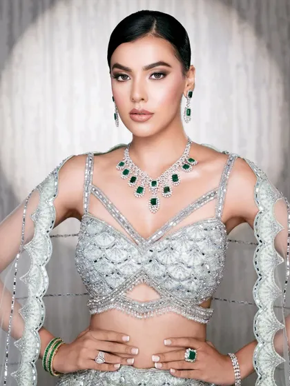 A strong and confident pose in a modern mint green lehenga. The focus is on the intricate beadwork of the blouse and the striking silhouette.