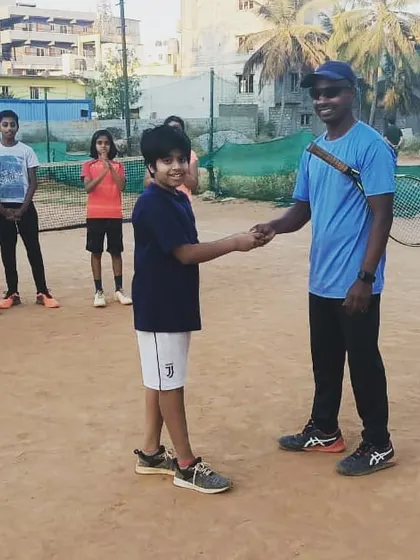 Congratulating Madhav for his excellent performance during the week's training sessions. This weekly recognition is a key part of our motivational tennis coaching approach.