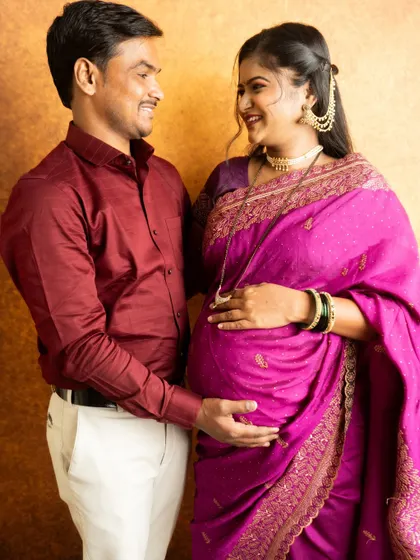 A close-up shot from a traditional saree session, capturing the happy and intimate connection between the expecting parents.