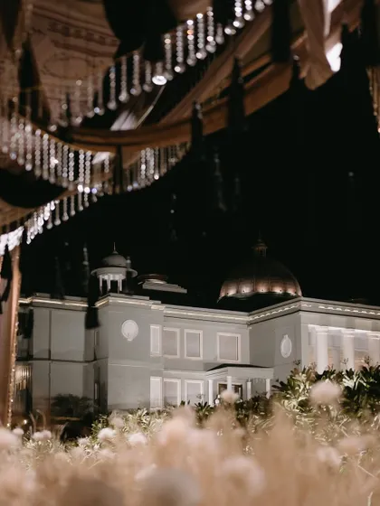 A view of the Raffles Udaipur palace at night, framed by the dreamy, white-themed Sangeet decor.