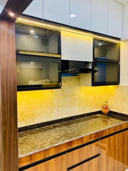 The cooking area of the kitchen, featuring dark glass lift-up cabinets and a granite countertop.