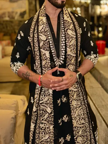 A close-up of our black kurta, paired with a beautifully embroidered shawl. The detailed threadwork on both the kurta and the shawl showcases our commitment to fine craftsmanship.