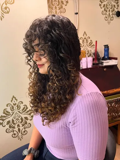 A side view showing the cascading layers that give her long curls definition.