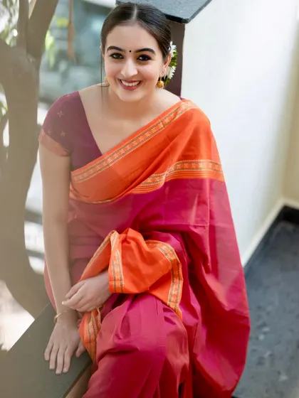 A bright, happy smile that lights up the frame. This shot captures the pure joy and beauty of wearing a traditional saree.