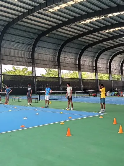 A wide view of our covered courts filled with players during a group training session, highlighting the scale of our high-performance program.