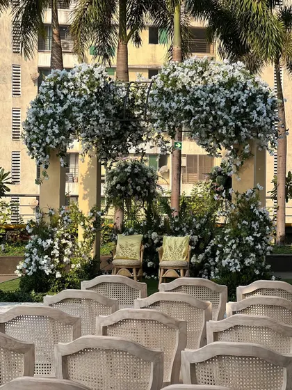 A beautiful Haldi seating for the couple, framed by an arch of lush white flowers. The natural, minimalist aesthetic creates an intimate and elegant setting.