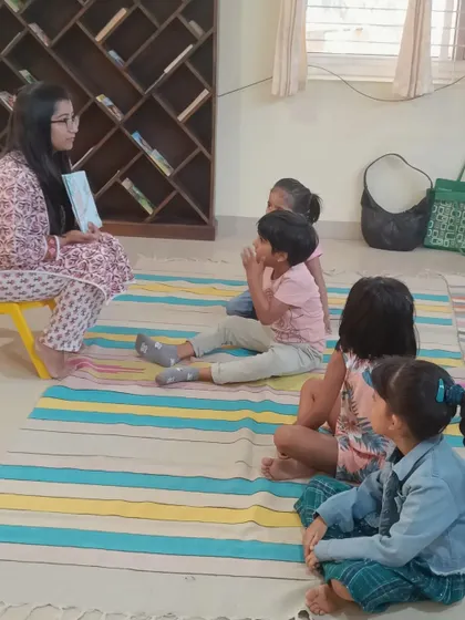 The children sit comfortably on the mat, ready for a story about parental love and friendship.