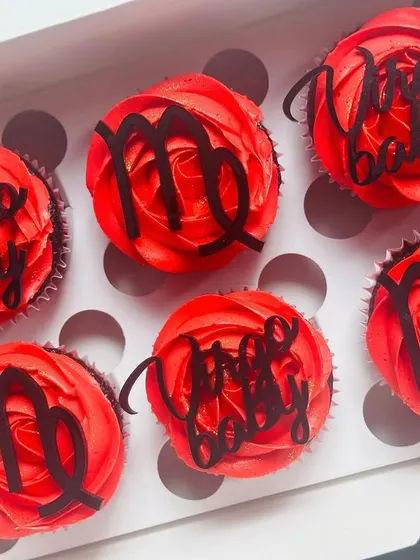 An overhead view of the "Virgo baby" cupcakes, showing the full set of six in their gift box. The vibrant red frosting makes a bold statement.