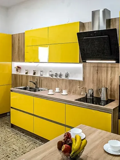 A bold and cheerful kitchen design with glossy yellow cabinets and wood-grain accents. This space is designed to be bright and uplifting, with plenty of counter space and integrated appliances.