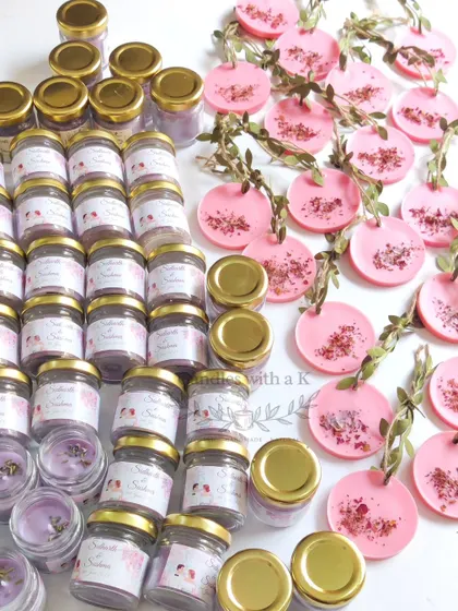 A beautiful set of wedding favors, including mini jar candles with lavender buds and pink wax sachets with rose petals.