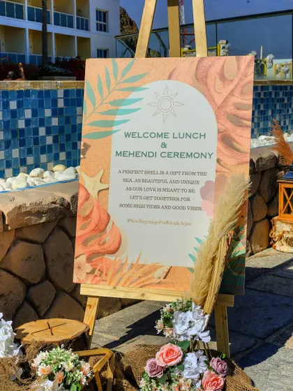 The welcome sign for the beachside Mehndi and lunch, featuring a beautiful watercolor design with a heartfelt message for the guests.