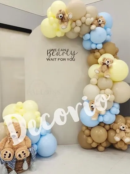 Here is another take on the "We Can Bearly Wait" theme, using a soft color palette of blue, yellow, and tan. The balloon arch is dotted with tiny teddy bears, adding an extra layer of detail and charm to the baby shower decor.